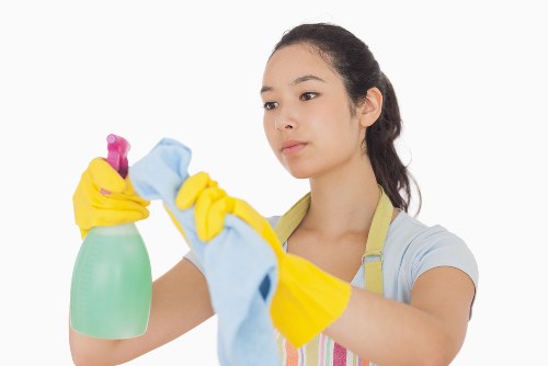 Cleaner working on a shared bin store and communal space in Harrow
