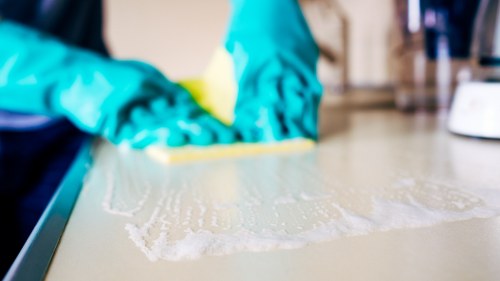 Professional cleaner handling equipment and chemicals carefully
